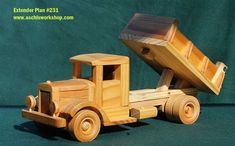 a wooden toy truck with a large piece of wood in it's back end