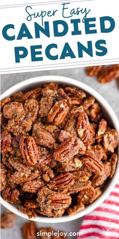 a white bowl filled with candied pecans on top of a red and white striped napkin