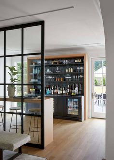 an open bar with stools in front of it and shelves full of bottles on the wall