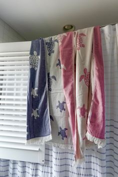 three towels hanging on the side of a window