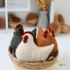 three knit chickens sitting in a woven basket