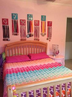 a bed room with a neatly made bed and lots of colorful decorations on the wall