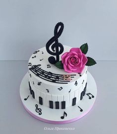 a cake decorated with musical notes and a pink rose