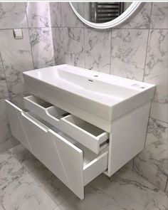 a white sink sitting under a mirror in a bathroom