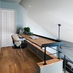 a wooden desk sitting on top of a hard wood floor next to a white door