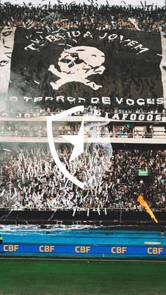 a large banner is in the middle of a soccer field as fans watch from the stands