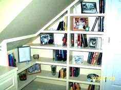 a book shelf in the corner of a room with many books on top of it