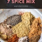 a plate filled with different types of spices on top of a white tablecloth next to a black and red sign that says 7 spice mix