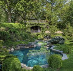 an outdoor swimming pool surrounded by lush green trees