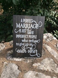 a wooden sign that says a perfect marriage is just two imperfect people who refuse to give up on each other