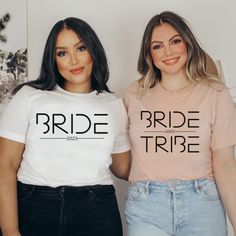 two women standing next to each other wearing t shirts that say bride and bride tribe