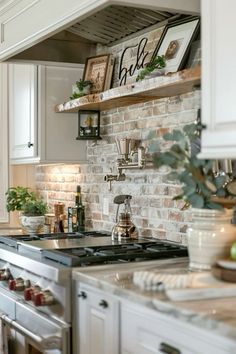 a kitchen with white cabinets and brick wall