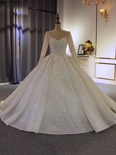 a white wedding dress on display in a room