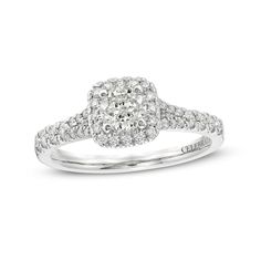 a white gold ring with diamonds on the band and an oval shaped center stone in the middle