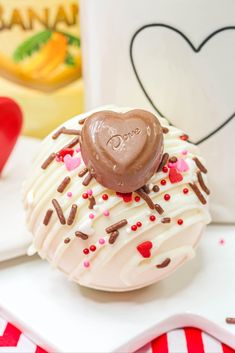 a heart shaped chocolate covered doughnut sitting on top of a plate