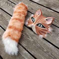 an orange and white cat laying on top of a wooden floor next to a stuffed animal