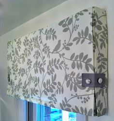 a window valance with grey and white leaves on it