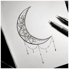 a drawing of a crescent moon and some pens