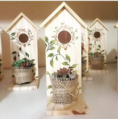 small wooden bird houses with flowers in them