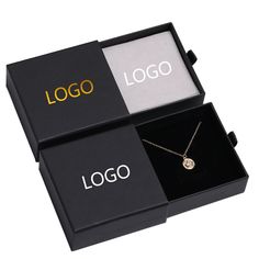 two black boxes with logos on them and one has a necklace in the middle that says logo