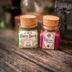 two jars filled with different colored liquid sitting on top of a wooden table