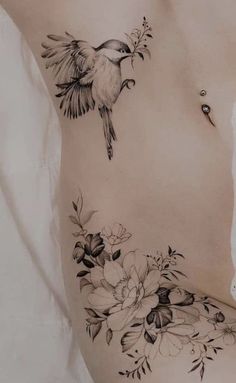 a woman's stomach with flowers and a bird on the side, in black and white