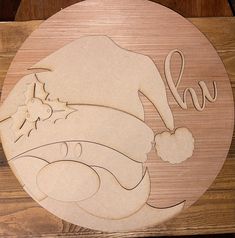 a wooden cutting board with a santa hat on it's head and the word love spelled in cursive writing