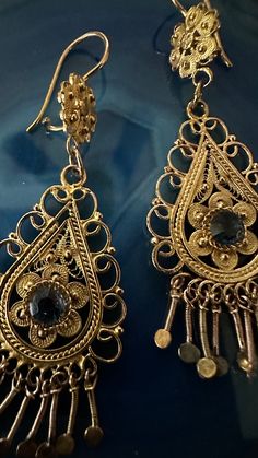 "A beautiful and elaborate pair of vintage cannetille earrings. These outstanding earrings are made of buttery 10k yellow gold (not marked but tested) crafted with fine cannetille wirework. Each earring is comprised of a two-parts that is intricately layered and hangs from a decorative surmount. Delicate gold beadwork, twisted rope wirework, and swirled floral accents decorate the earrings and fringed accents dangle freely from the bottom.  The surmounts have a complimentary cannetille design, and on the back of each topper is a gold wire. A unusual and exquisitely crafted pair of earrings, they are a magnificent example of cannetille work. They would be perfect everyday earrings and would make a wonderful addition to any vintage collection! Each earring hangs approximately 2 1/2\" long, m Ornate Antique Gold Dangle Jewelry, Ornate Antique Finish Dangle Earrings, Antique Gold Filigree Dangle Earrings, Antique Filigree Dangle Chandelier Earrings, Vintage Brass Filigree Chandelier Earrings, Vintage Gold Earrings, Dangling Earrings, Gold Wire, Everyday Earrings