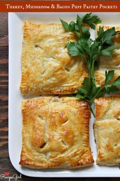 four puff pastry squares on a white plate with parsley garnished in the middle