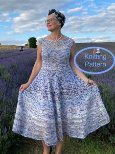 a woman standing in a field wearing a dress