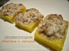 three pieces of food sitting on top of a white plate covered in cheese and sauce