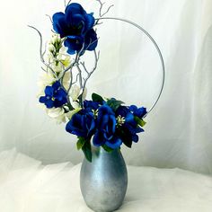 a silver vase filled with blue and white flowers