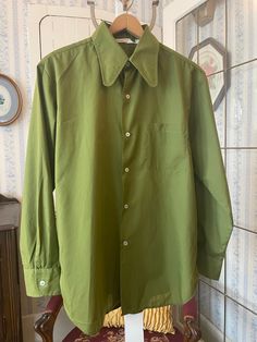 This shirt, from Capri West by Townline, is made from a silky blend of 65 per cent polyester and 35 per cent cotton in a rich shade of olive or mossy green. It has the original buttons in the front and on the cuffs, one chest pocket and a pointy collar. Marked size 16 to 16 1/2 inch neck. The measurements, taken with the shirt lying flat, are: shoulder to shoulder, 19 inches; armpit to armpit, 24 inches; sleeves, 25 inches; length, 31 inches; bottom edge, 24 inches. In very good condition. Green Collared Shirt, Green Button-up Shirt, Casual Green Button-up Dress Shirt, Vintage Green Button-up Shirt, Green Military Style Button-up Shirt, Olive Cotton Button-up Shirt, Pointy Collar, Green Button, Green Shirt