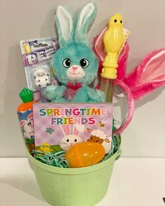 a green bucket filled with toys and a sign that says springtime friends on it