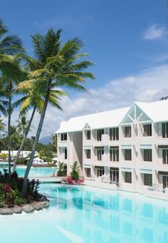 an outdoor swimming pool surrounded by palm trees