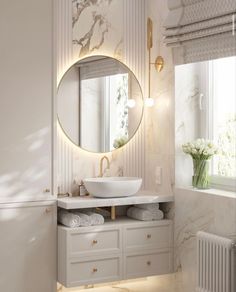 a bathroom with marble walls and flooring, a round mirror on the wall above the sink