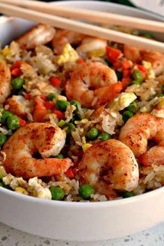 shrimp, peas and rice with chopsticks in a bowl