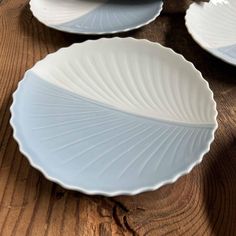 three white plates sitting on top of a wooden table