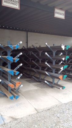 several steel beams are stacked on top of each other in a storage area with signs above them