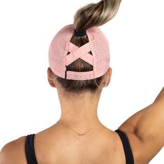 the back of a woman's head wearing a pink visor