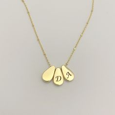 "14k solid yellow gold necklace with a 3 teardrops pendant with black diamonds and engraved letters, layered solid gold necklace for women. This 14k yellow gold necklace has 3 teardrop pendants. One of the pendants has black diamonds on the back and the other 2 have one engraved letter each. This necklace is light and shiny, perfect for everyday use. It will complement any look you choose whether it is classic, boho-chic, street style, and more... You can wear it as a single, minimalist necklace Gold Sterling Silver Teardrop Charm Necklaces, Gold Drop Necklaces In 14k Gold, Gold Sterling Silver Teardrop Pendant Necklace, Gold Sterling Silver Teardrop Necklace, Gold Teardrop Pendant Drop Necklace In Sterling Silver, Gold Teardrop Jewelry Stamped 14k, Gold Sterling Silver Dangle Drop Necklace, Gold Sterling Silver Drop Necklace For Anniversary, Personalized Yellow Gold Dangle Necklaces