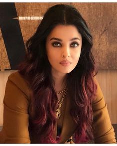 a woman with long dark hair sitting at a table