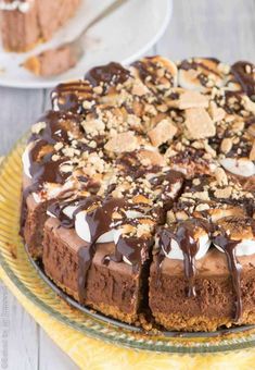 a chocolate cake with marshmallows on top is sitting on a yellow plate