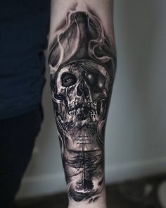 a man with a skull and ship tattoo on his arm