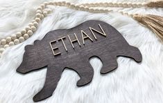 a wooden sign with the word ethan on it and a tassel around it