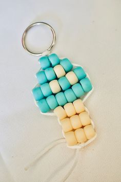 a keychain made out of beads sitting on top of a white tablecloth