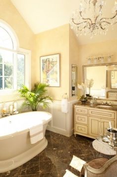 a large bathroom with a tub, sink and chandelier