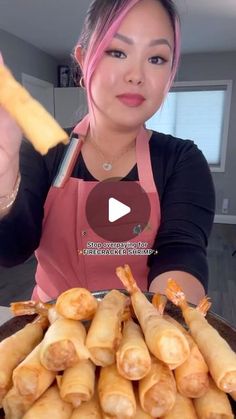 a woman in an apron is holding up some food