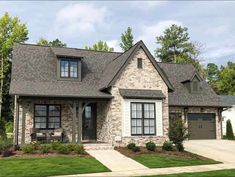 a brick and stone house with two garages