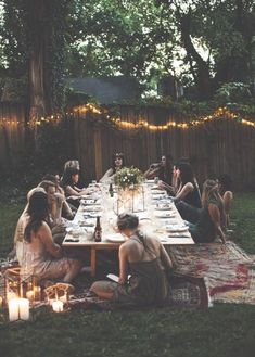 a group of people sitting around a table with food and drinks in front of them